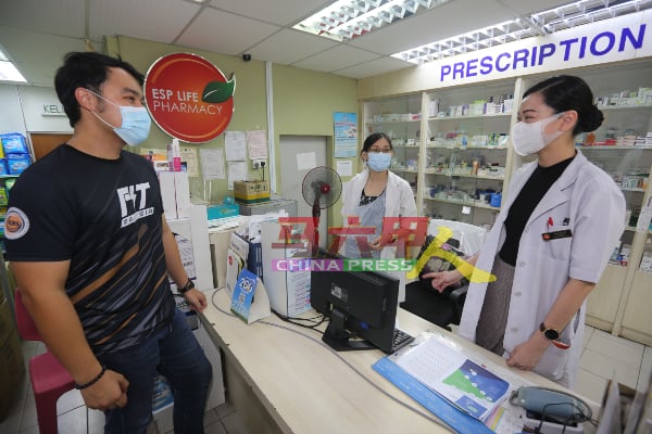 郭子毅（左起）与两位药剂师符慧钰及蓝迎华，针对接种疫苗资讯进行交流。