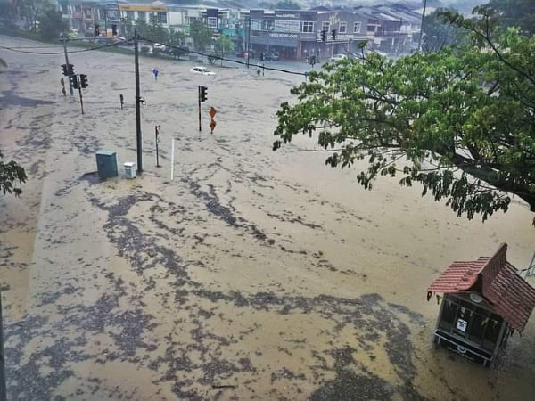 晋巷柏达纳前十字路口周一上午下大雨时淹水，一辆轿车困于水中。（图取自网络）