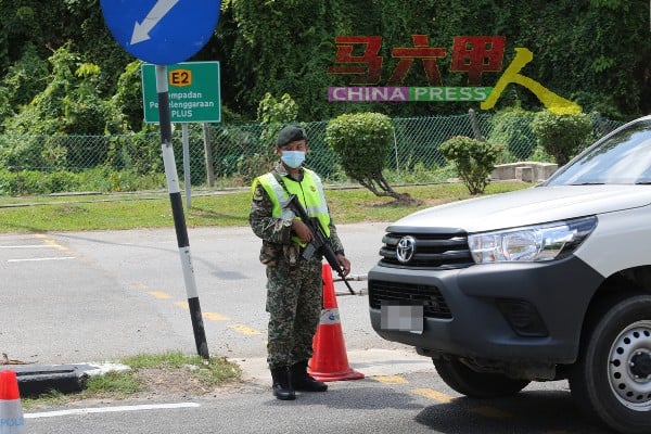 荷枪实弹的军人在收费站的路障驻守。