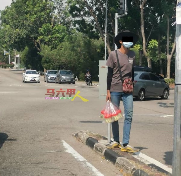 小贩手拿芒果酸，在路中来回走动，售卖芒果酸，可被执法单位取缔。