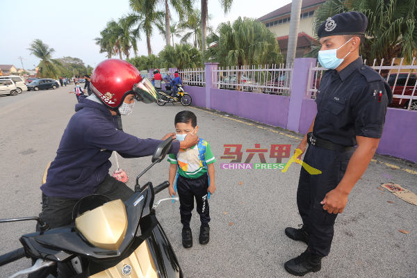 警务人员监督家长为孩子载好口罩。