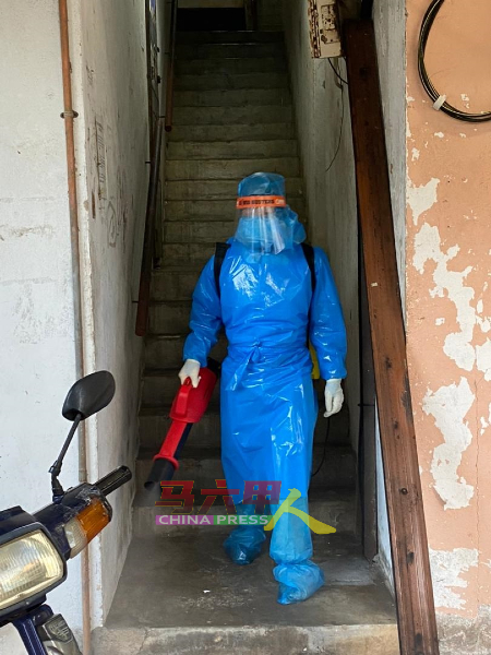 志工前往组屋消毒，穿上不透风的防护衣，上下楼梯，消毒工作并不简单。