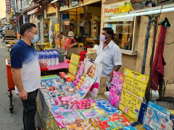 颜天禄（左）走访鸡场街夜市时与商贩业者交流。