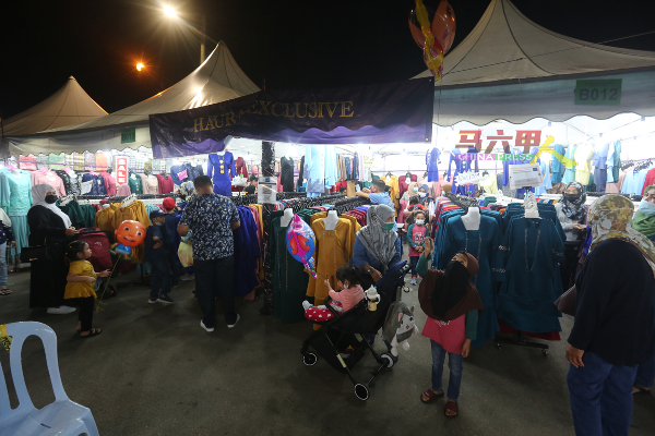 售卖马来传统服装的摊位，生意火热，人潮汹涌。