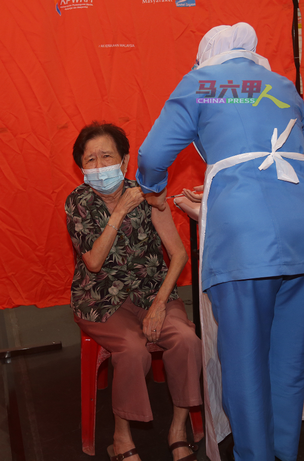 护士为一名长者注射疫苗。