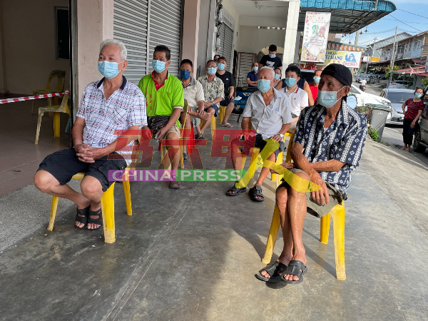 村民在马接峇鲁新村民众会堂外等候，以进行冠病检测。