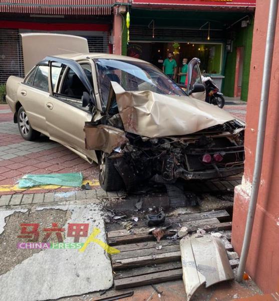 轿车失控撞击红屋商店前的石柱，造成轿车前部严重被撞毁。（照片由警方提供）