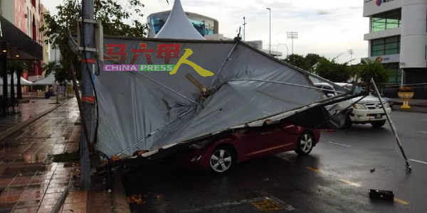 帐篷遭风雨吹倒，压中一辆轿车。