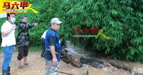 郭子毅（左）向居民了解泥浆水从山上流下的情况。