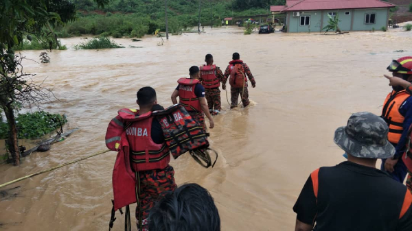 消拯员出动绳索的协助，横跨急流的淹水区到甘榜民宅，协助灾民逃往安全地点。（图消拯局提供）