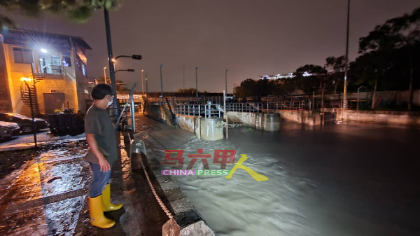 刘志俍观察马六甲河口水闸排水情况。
