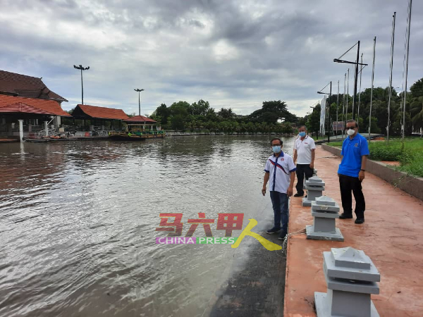 马六甲河下游于周二早上11时，依然高涨。左起为刘志俍 、助理陈劲源及前姑务乡理会主席李祥生。