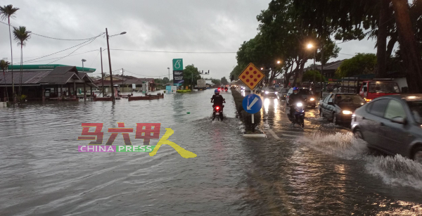 武吉南眉大路部分路段严重积水，车辆及摩哆冒险涉水而过。