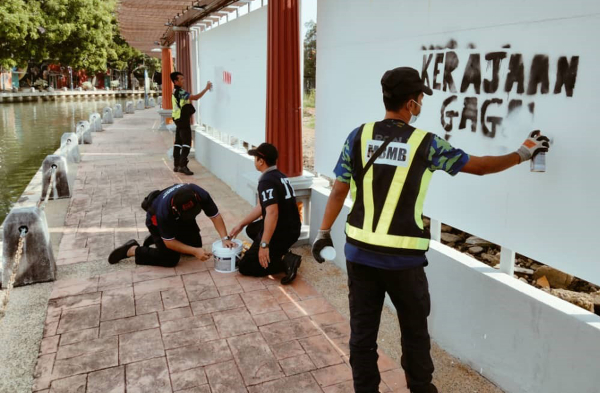 马六甲市政厅第一时间反应小组人员马上采取行动，清除涂鸦处。