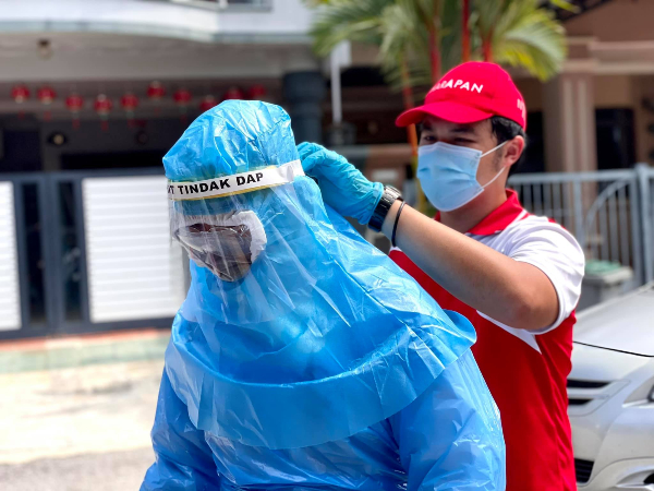 郭子毅（右）参与N16消毒特工队每一场消毒工作，亲自为队员穿上防护服。