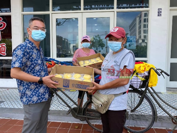 母女从直落垵骑脚车到哥打拉沙马那，亲自将菜包送到邱培栋（左）手中。（图取自邱培栋面子书专页）