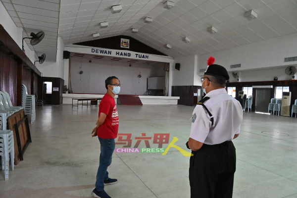 刘志俍（左）向保安人员了解情况。