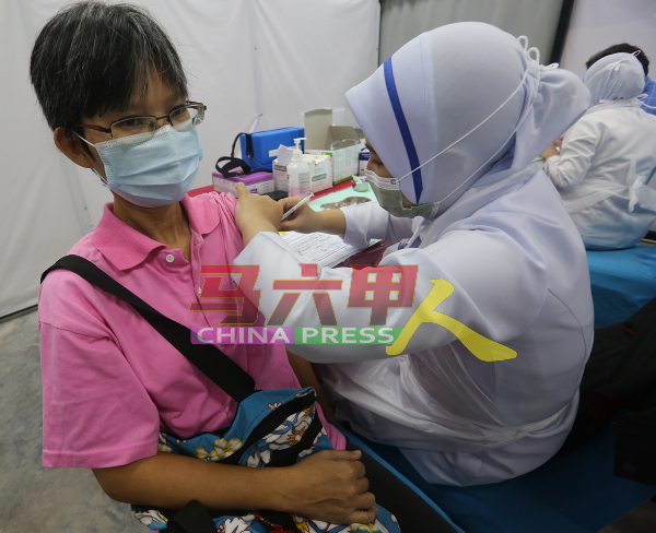 《中国报》记者姚美芹淡定地接受医护人员接种疫苗。