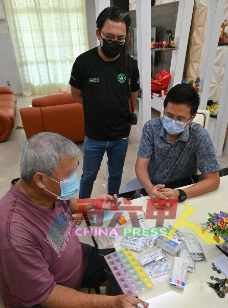 曾动过心脏手术的李志佳（坐者左），向谢守钦（坐者右）及梁恩来展示每日必须服的药物。