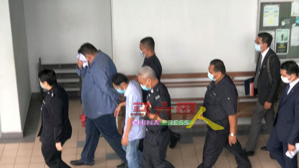 两名被告莫哈末化立（左2起）及阿都拉，由警员带离法庭。