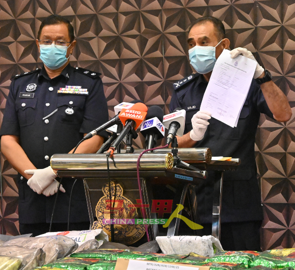 阿都马吉（右）展示嫌犯所使用的伪造警方批准信。