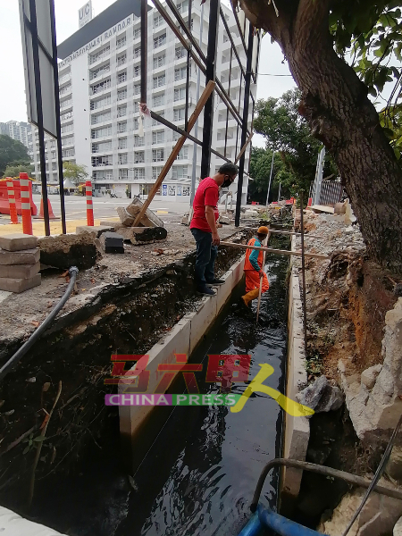 刘志俍向南方环境公司员工了解，沟渠受废弃物阻塞情况。