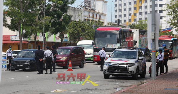 ■执法人员在马华公会大厦前进行检举，一一检查路过汉都亚路的车辆。