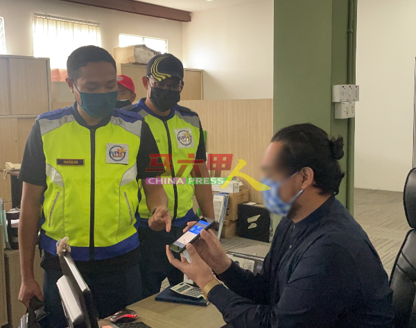 汉都亚再也市议会执法人员协助警方进行突击检查，确保员工有扫描MySejahtera签到。