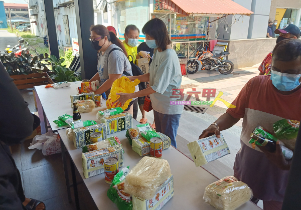 Hang Boba奶茶店负责人把食物放在桌上，让民众索取所需要的食物，因此，民众颇花时间选取食物。