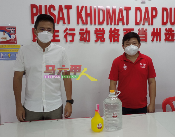 ■谢守钦（左）与张文杰展示将送给确诊者家庭的消毒水及喷洒具，以让确诊者居家自行消毒。