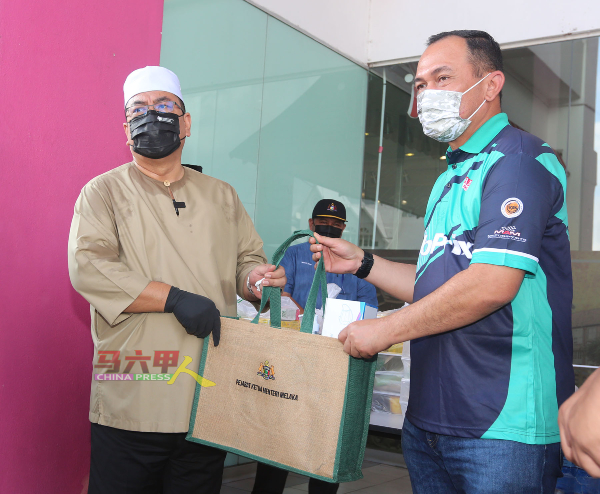 苏莱曼（左起）移交防疫用品和餐点给沙丹奥特曼，感谢辛勤付出的工作人员。