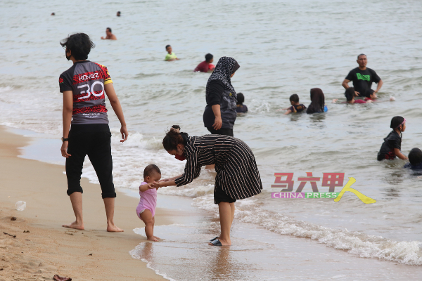 一些家庭也携带尚未能行走的幼童到海滩戏水。