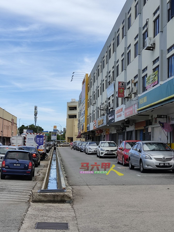 /■车辆泊在王金辉路，要到银行同排的商店办事，都必须绕道。
