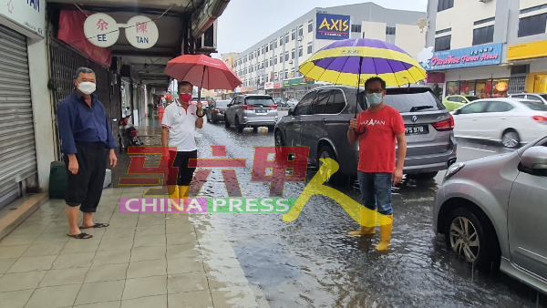 刘志俍（右起）及陈劲源到王金辉路视察，同时向商家了解水灾情况。