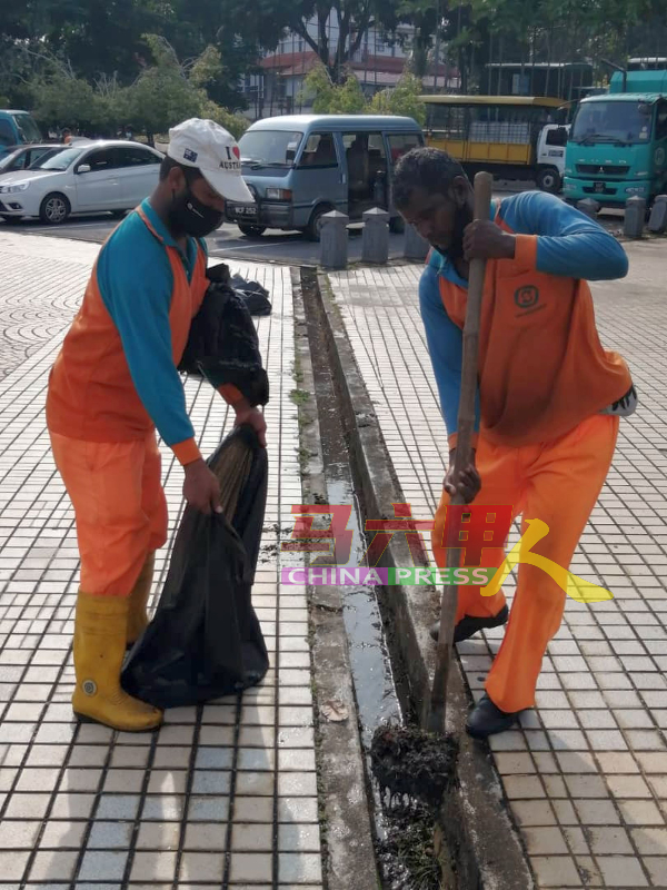■南方环境公司清洁工，清理排水沟的泥泞。