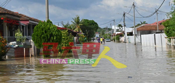 住宅区的马路被淹得看不到路，一些居民涉水而过，出外购买食物。