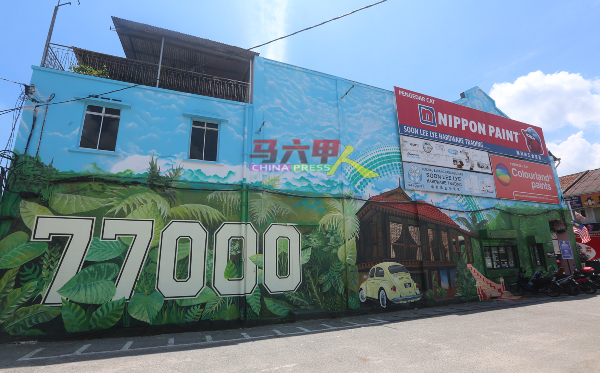 左边店铺的壁画绘有野新邮区编号77000及马来乡村风光。