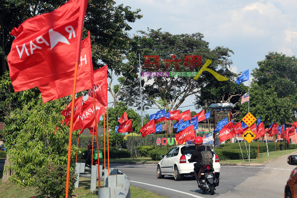 转入士马木达兰的路口交通岛及街边，尽是蓝色的国阵及红色的希盟旗帜，让人眼花缭乱。