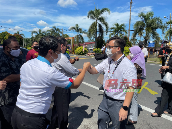 希盟公正党马接再也州议席候选人罗秉浩，与党员击拳打招呼。