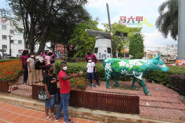 ■一些外州游客携同家人到马六甲旅游景点，如荷兰风车与乳牛塑像前自拍。