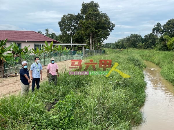 吴俊兑（中）在甘榜鲁伯葛少村长阿巴斯（左）及居民末扎安视察河床情况。