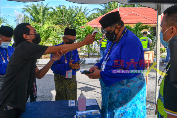 丹绒比达拉州议席国阵巫统候选人阿都拉勿（右2）抵达会场时，检测体温。