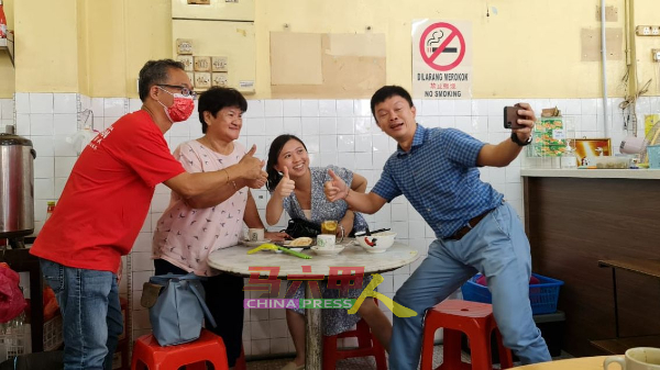 刘志俍（左）谢票时与选民合照留影。