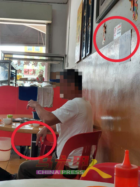 即使茶室墙上贴着禁止吸烟的告示牌，但该名烟民依然违禁吸烟。（图网民提供）