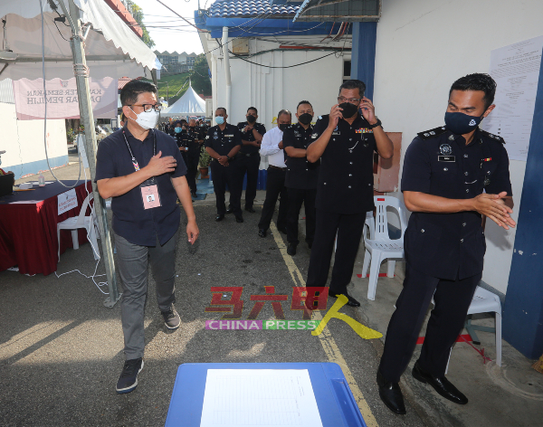 ■马华候选人李佳胜（左）向警员选民打招呼。