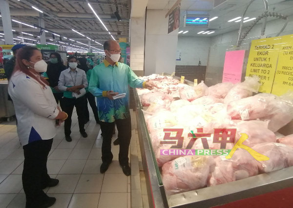 ■肉鸡近期价格高，引起消费者的投诉，魏喜森（右）巡视时，也了解超市出售的肉鸡价格，左为诺丽娜。