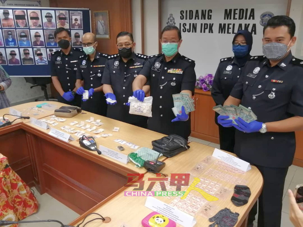 朱基菲里（右3）等展示警方从毒贩和吸毒者搜出的现金和各类毒品。