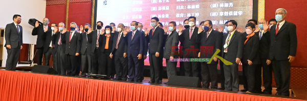 林万锋（左）为甲永春会馆理事会2021─2024年新届理事监誓。 