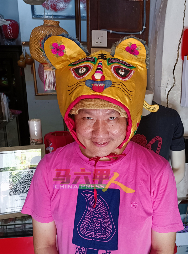 陈益龙展示逾千年历史的虎帽，是家长冀望孩子将来能向个老虎一样，威武凛然。