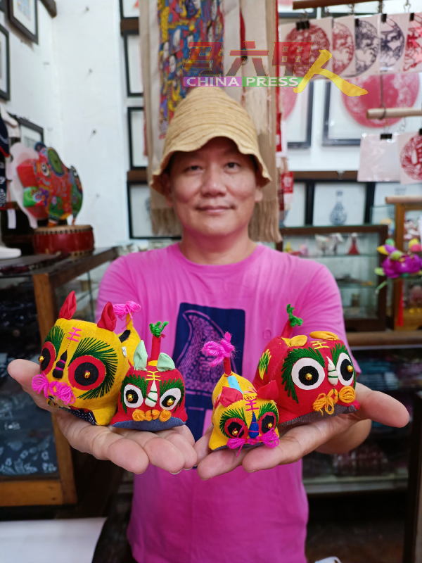 陈益龙向《中国报》记者展示中国逾千年历史的老虎布艺玩具。